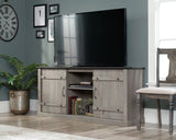 Modern farmhouse TV stand in Mystic Oak with sliding barn doors and storage shelves